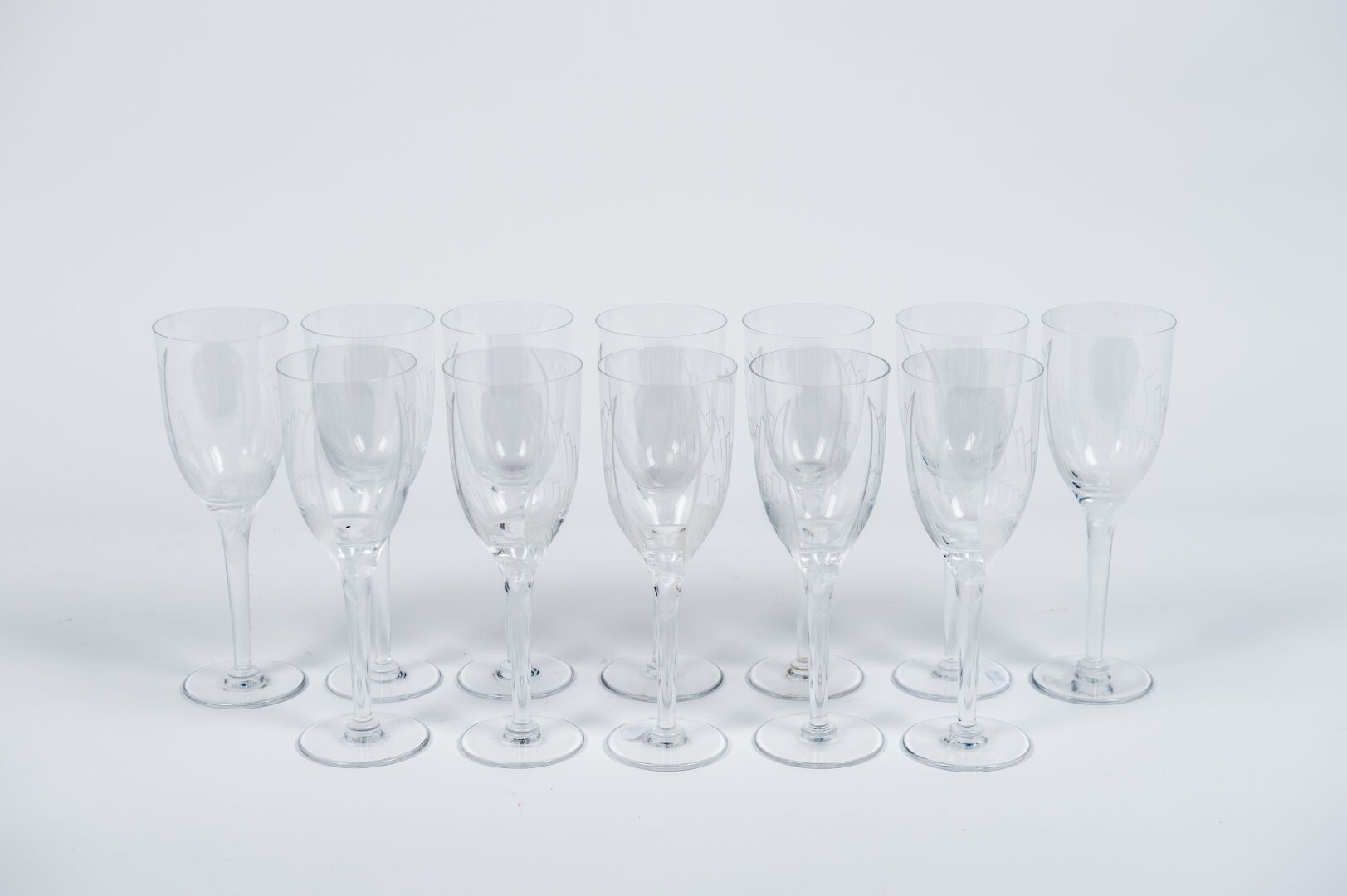 Null LALIQUE.12只水晶香槟杯套装，型号为 "Ange"，创作于1948年，以兰斯大教堂的微笑天使为原型，已签名（高：21厘米）。