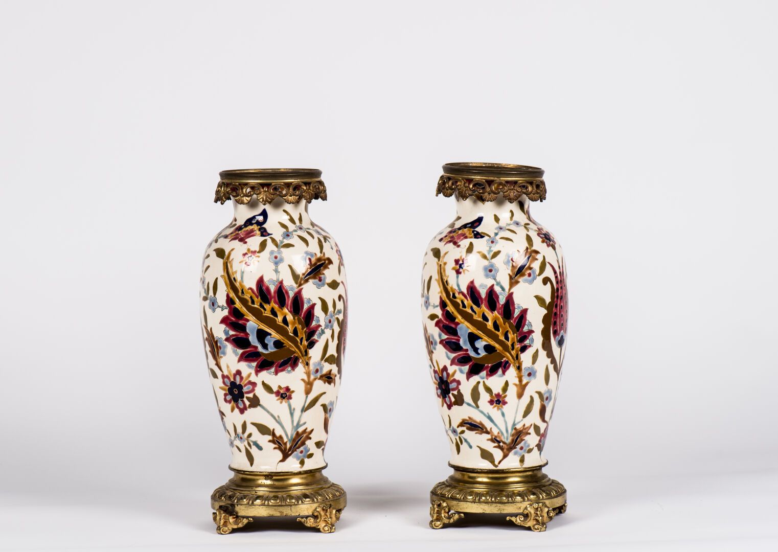 Null 一对多色珐琅彩陶器花瓶，有鎏金的亮点，装饰有波斯风格的叶子，鎏金的青铜支架。一个背面有模糊的凹痕（高：45厘米）