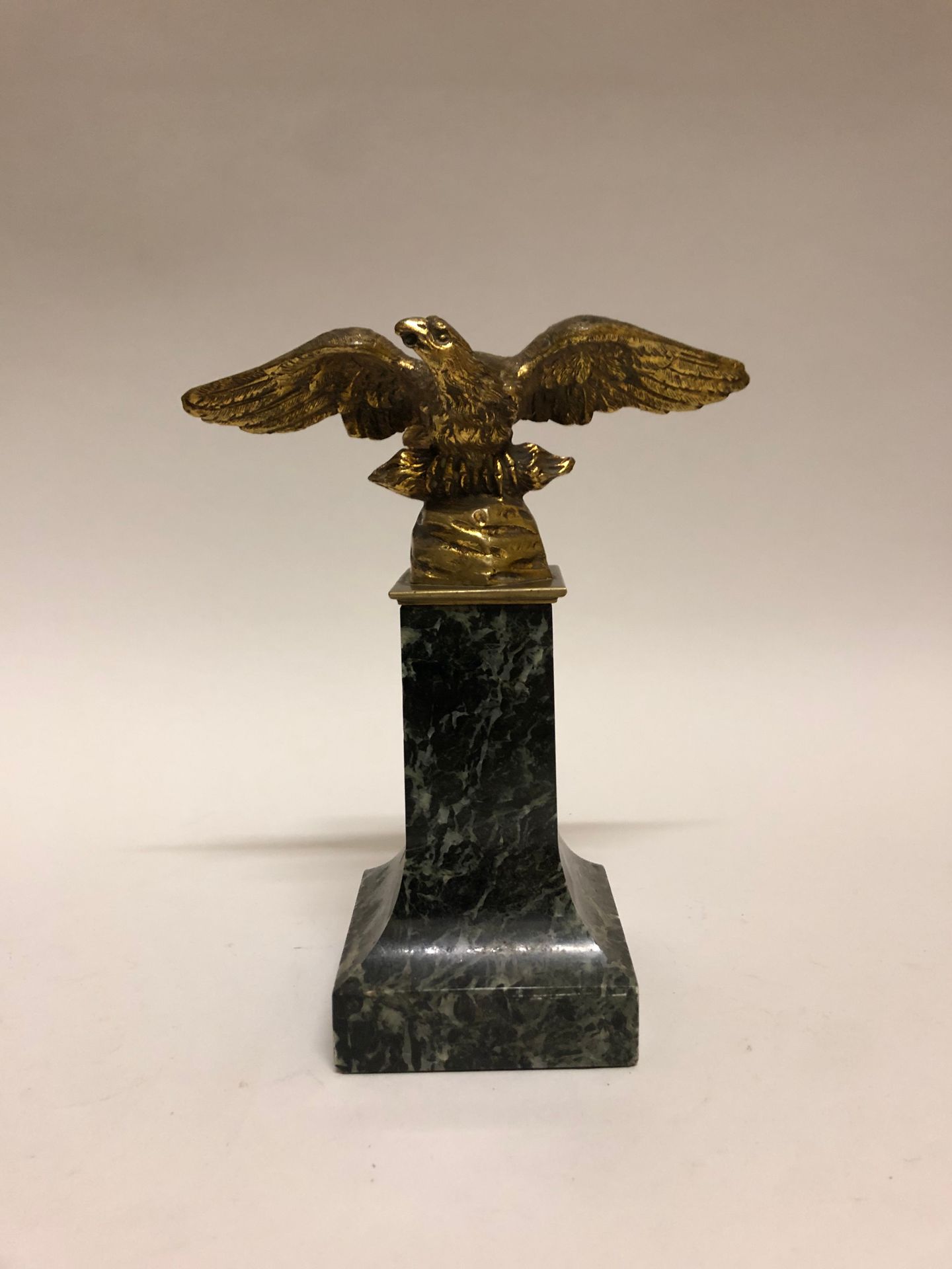 Null Un águila de bronce dorado sobre una base de mármol verde. Altura: 18 cm.