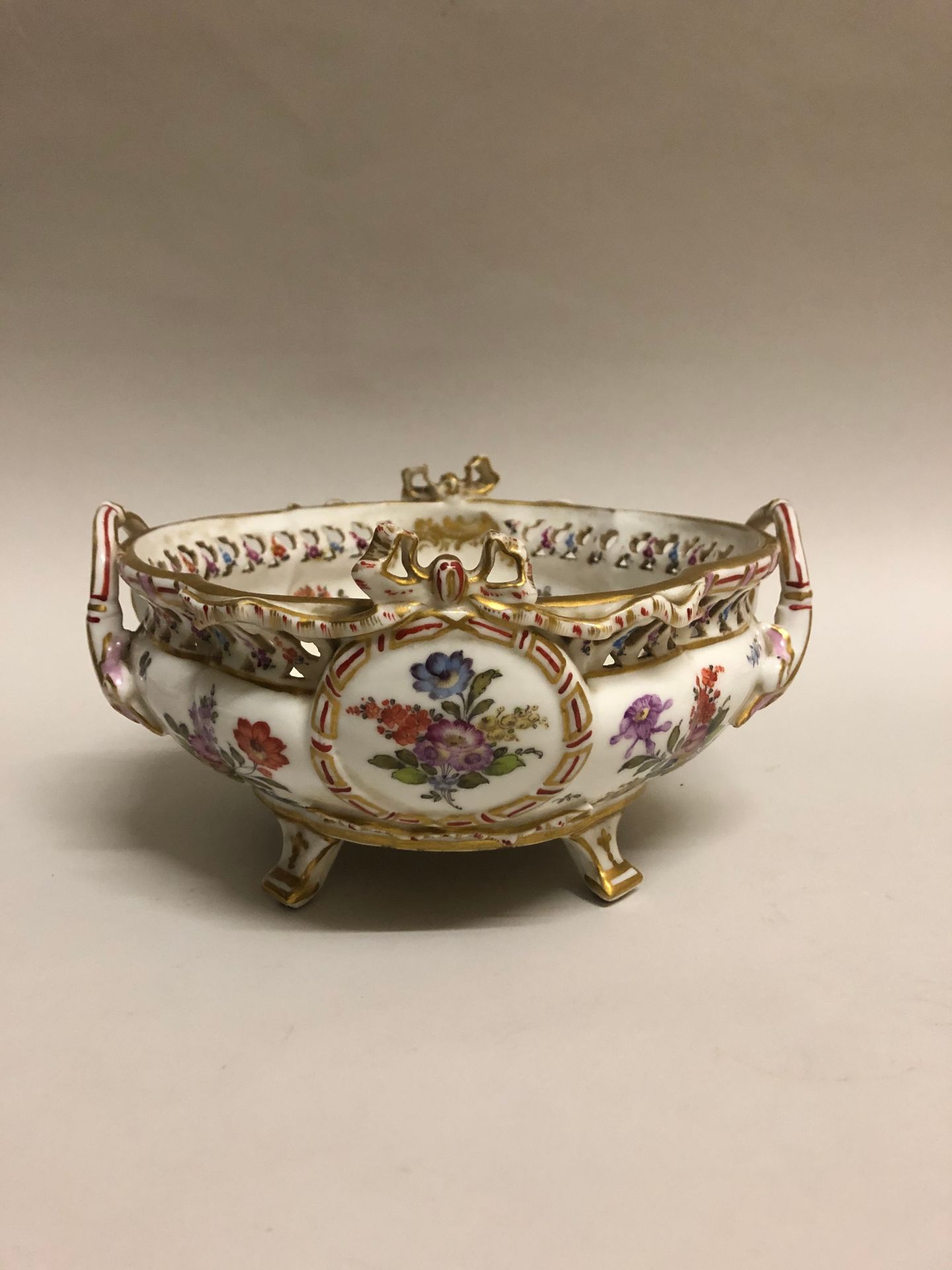 Null 一个多色珐琅彩瓷杯，手柄饰有篮子里的花朵，置于四脚之上。萨克森州，18世纪。高度：21厘米。