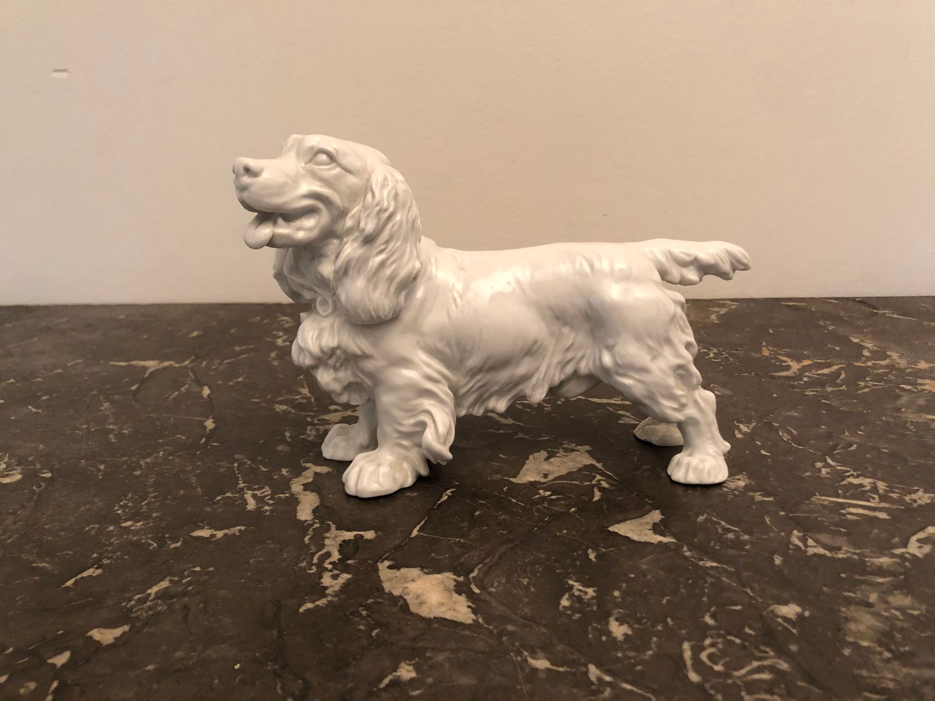 Null MEISSEN，19世纪。白色珐琅彩瓷器的可卡犬。用交叉的剑做标记。高度：14厘米。高度：14厘米