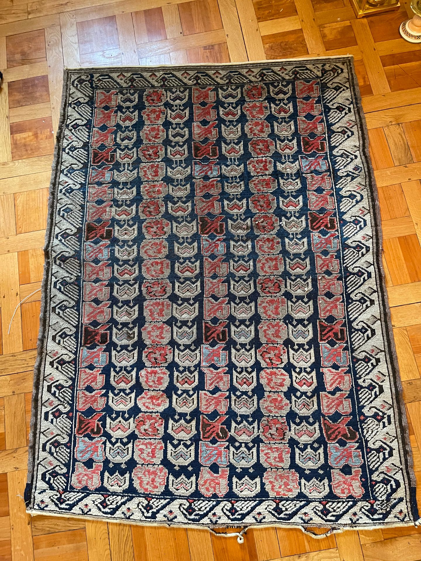 Null 东方羊毛地毯，在午夜蓝色背景上装饰有红色和白色的几何图案（磨损）。170 x 123 cm