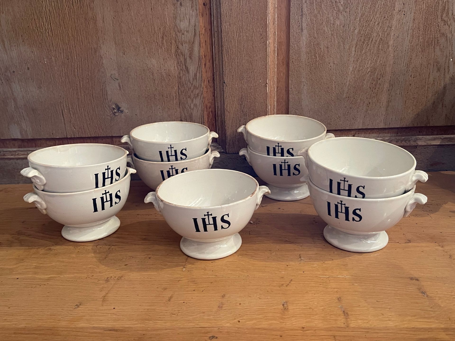 Null 九个白色陶器社区碗，上面刻有 "IHS "字样。