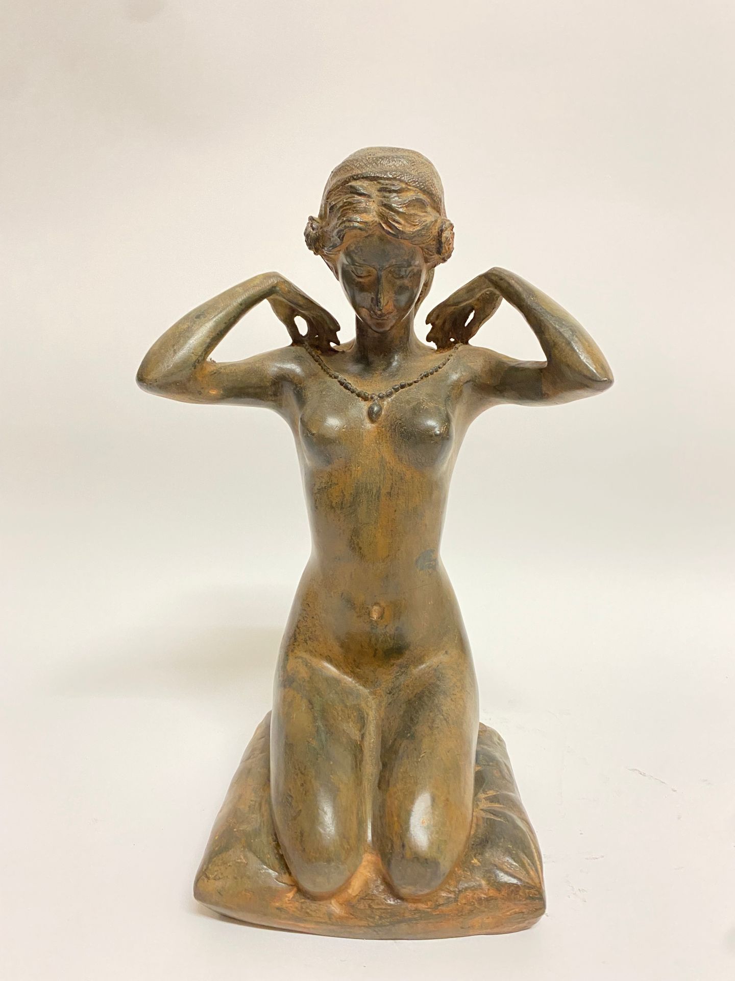 Null Pierre CHENET (XXth century). Kneeling woman wearing a necklace, bronze wit&hellip;