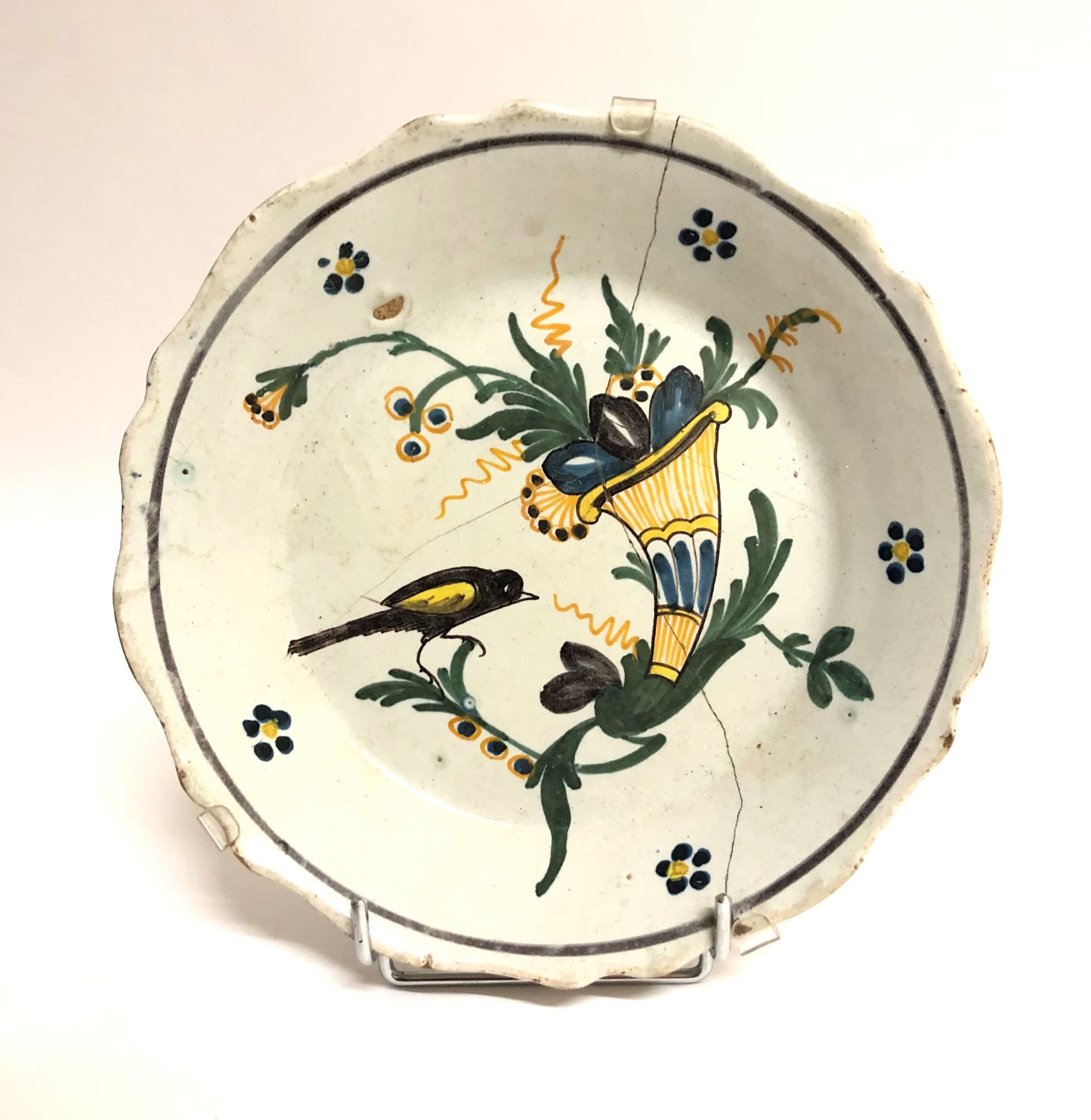 Null NEVERS，18世纪。一个陶制盘子，边缘有轮廓，装饰有玉米棒。直径：23厘米（有裂缝和装订）。