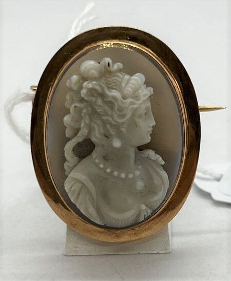 Null 玛瑙浮雕金胸针，上面有一个戴珍珠项链的女人的轮廓

19世纪晚期

毛重 : 16,5 cm - 长度 : 3,5 cm