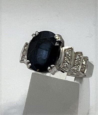 Null 白金戒指，镶嵌着一颗美丽的椭圆形蓝宝石（约4克拉）和16颗长方形切割钻石

毛重：7.5g TDD：54