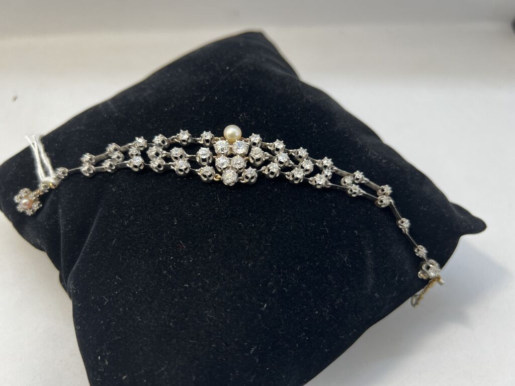 Null 黄金手镯，镶嵌钻石和养殖珍珠的3行连接在一起，花扣镶嵌珍珠及其安全链（最重要的钻石的重量：约0.35克拉）

19世纪末的作品

长度 : 18 cm&hellip;