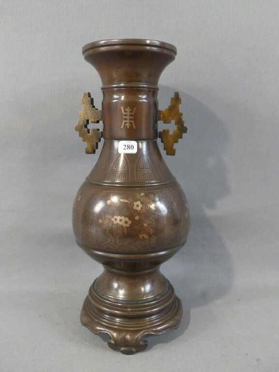 Null 越南，19世纪末
阳台形的青铜花瓶，装饰有铜和银丝镶嵌的花和字。
H.30厘米