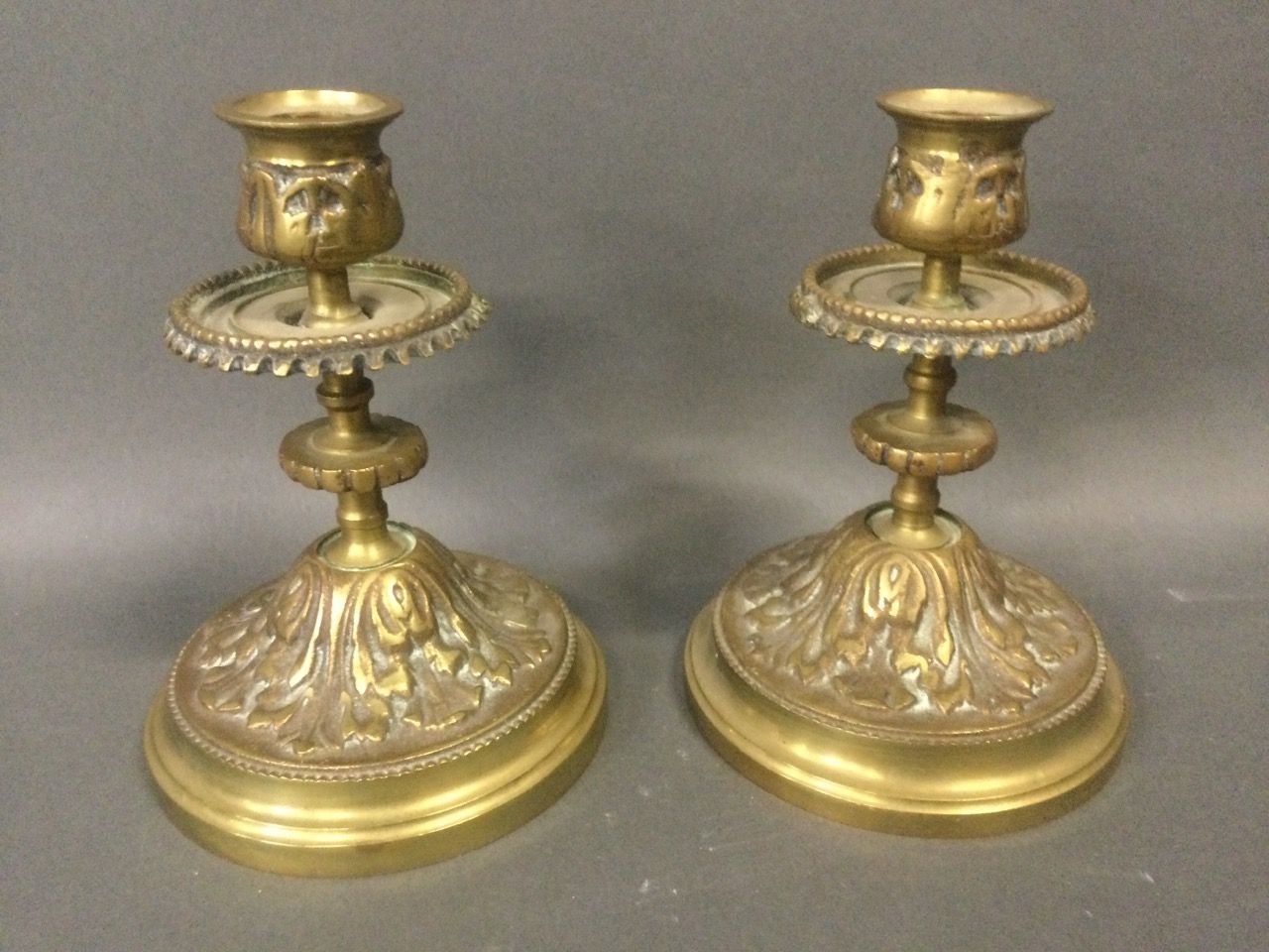 Null Paire de BOUGEOIRS en bronze doré et ciselé à décor de feuillage, H. 14 cm.