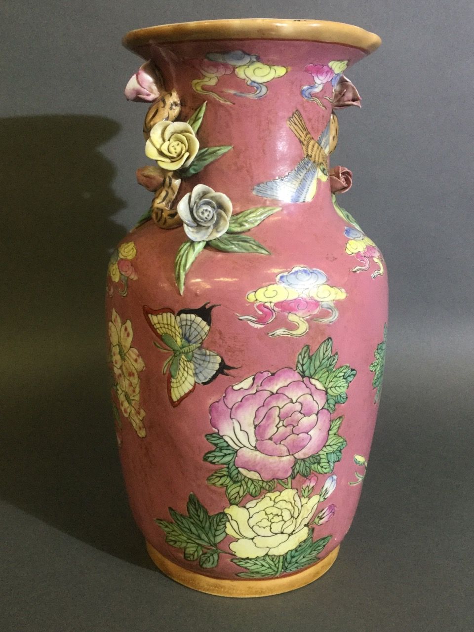 Null 中国，陶器花瓶，浮雕装饰，粉色背景上有花、蝴蝶和鸟。在颈部，两个花枝构成了一个浮雕的装饰。20世纪初，高36厘米