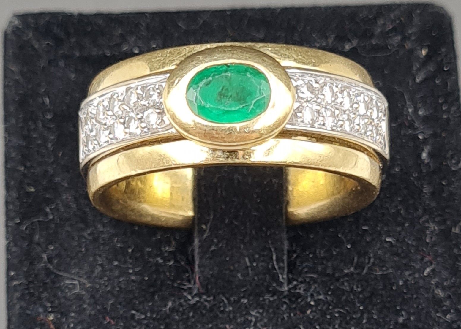 Null 18K黃金戒指，鑲嵌一顆橢圓形祖母綠（已磨損），兩側由兩行10顆明亮式切割鑽石圍繞，印有貓頭鷹標誌，總重量為16.79克。