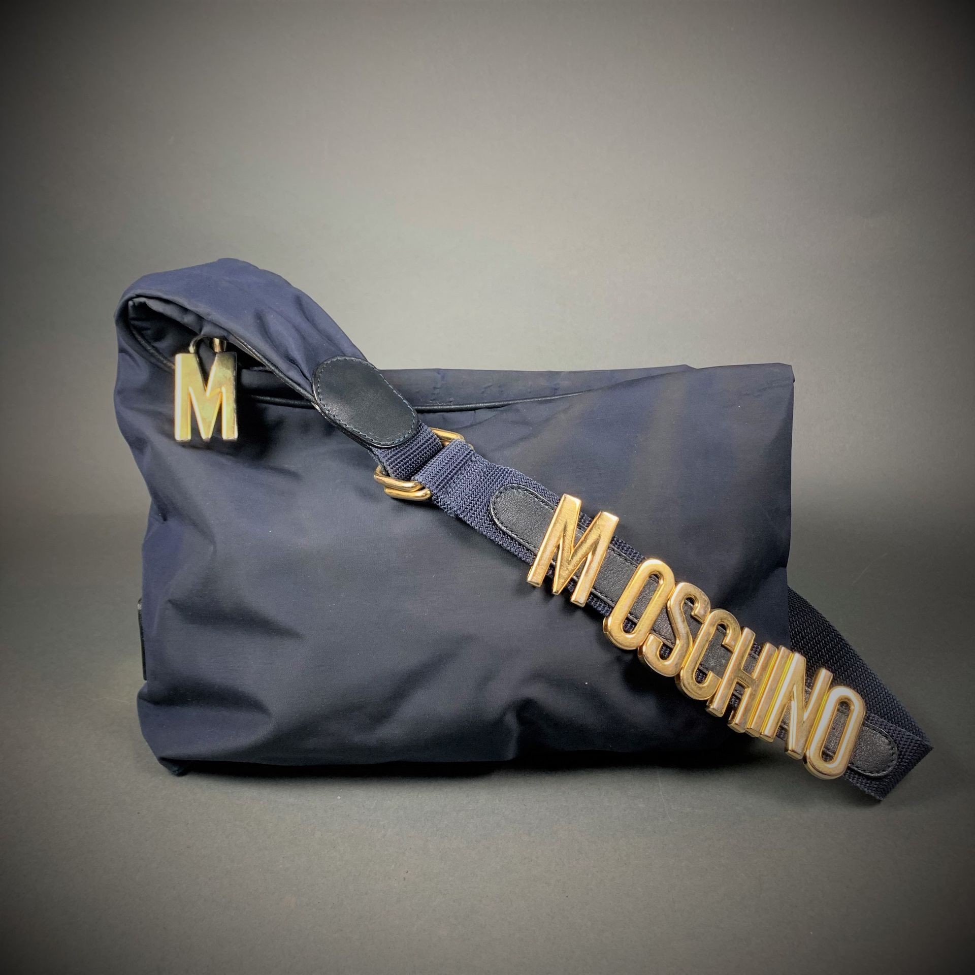 Sac MOSCHINO in blue canvas, gold metal trim, opens with a zipper revealing a bl&hellip;