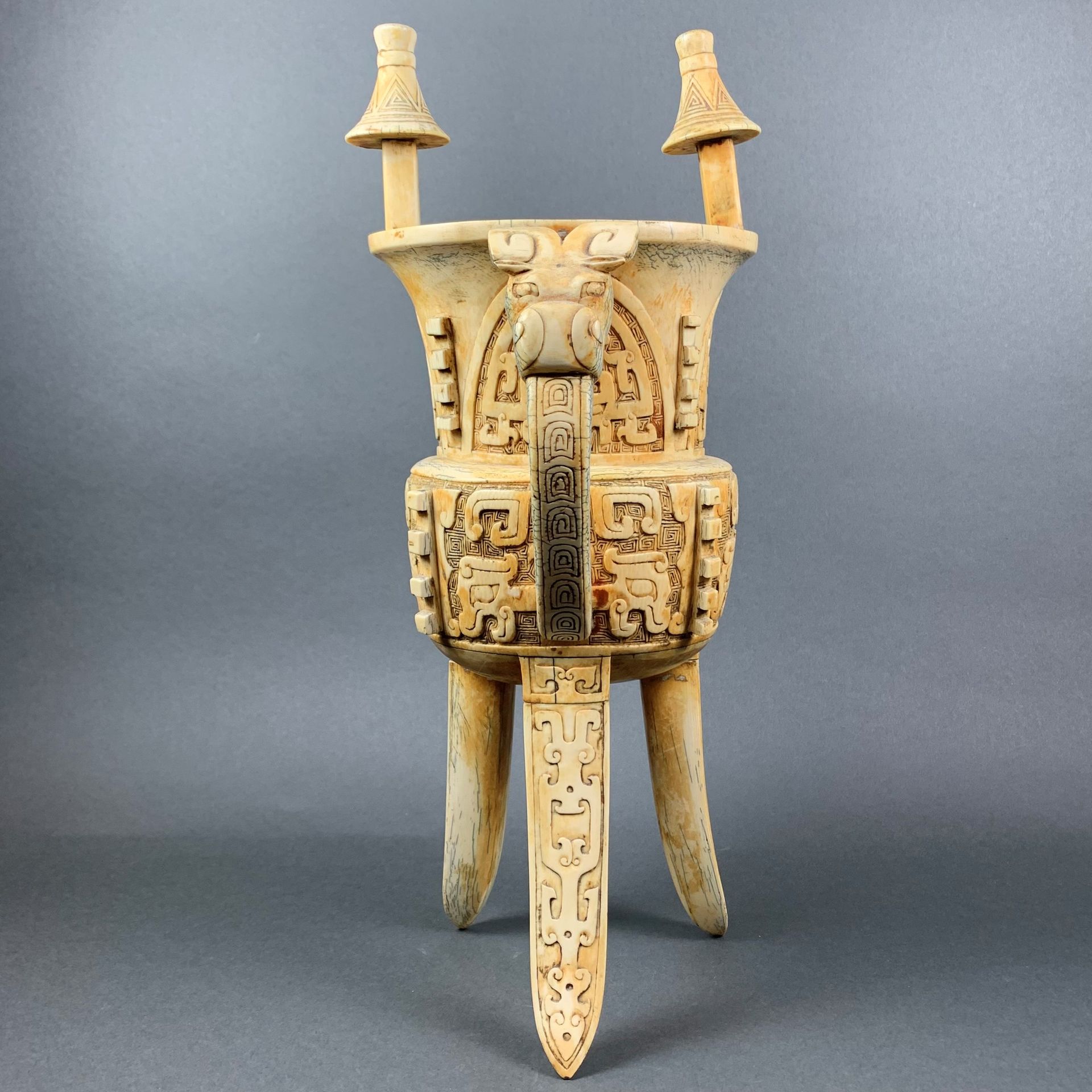 Chine, milieu XXe siècle 一个象牙 "觉 "形的酒瓶，在希腊背景上雕刻着饕餮面具。脚上雕刻着几何图案，高。27厘米。不可能有CITES，&hellip;