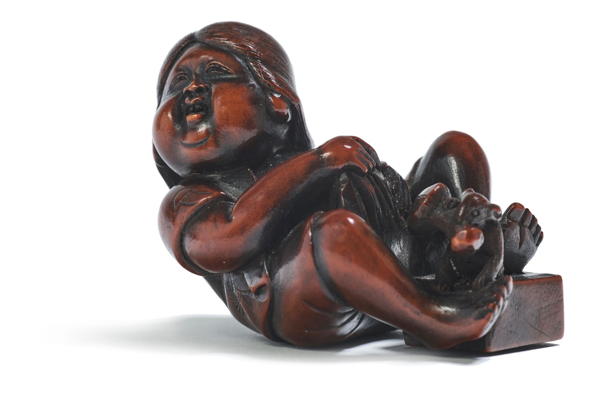 JAPON - XIXE SIÈCLE Wooden netsuke, laughing Okame sitting with her feet on a bo&hellip;