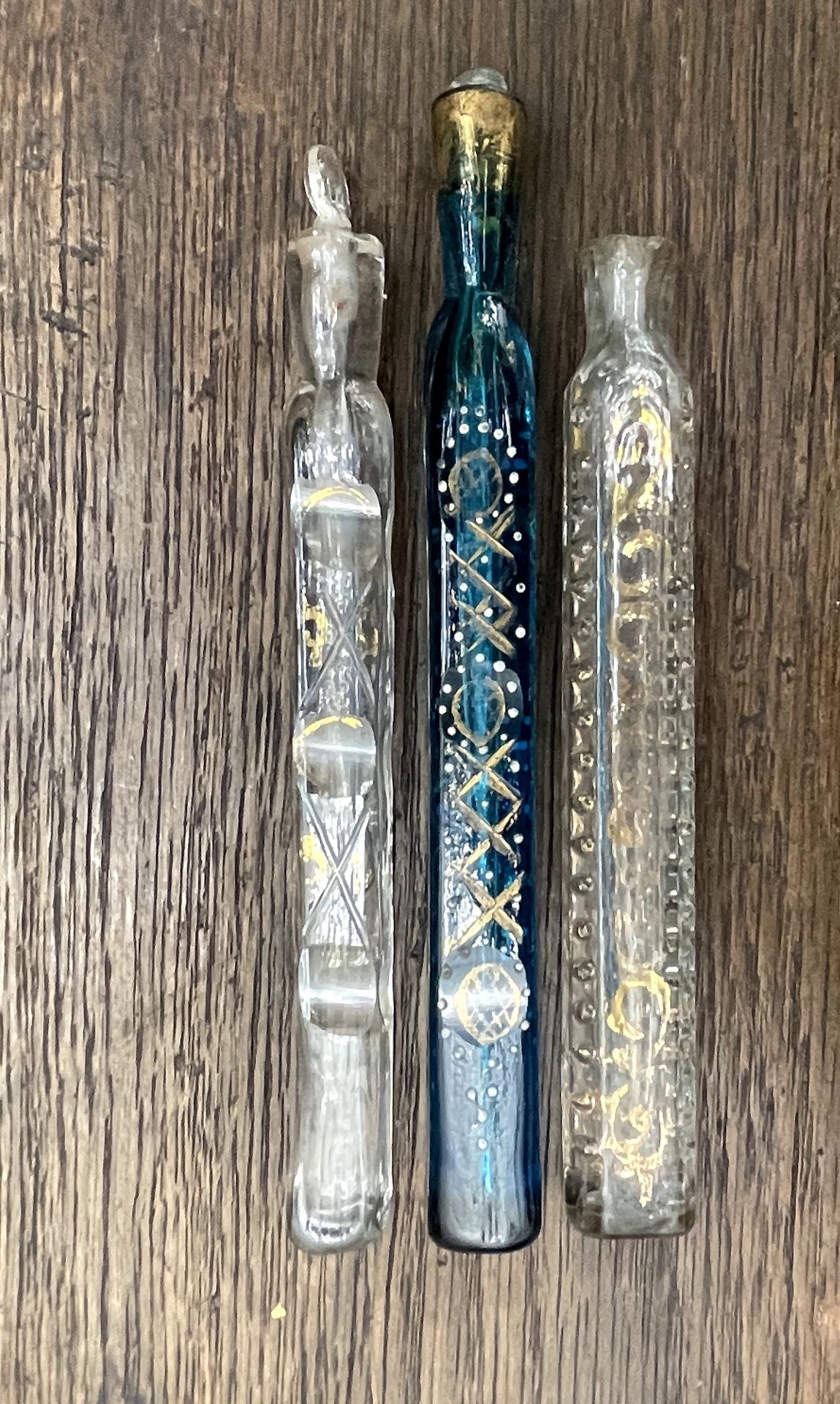 Null 
三个吹制的玻璃香水或药膏瓶，装在有金色造型图案的护套中。


19世纪。


一个16.5厘米的高度


(破损，磨损，一个塞子丢失，一个被封锁)