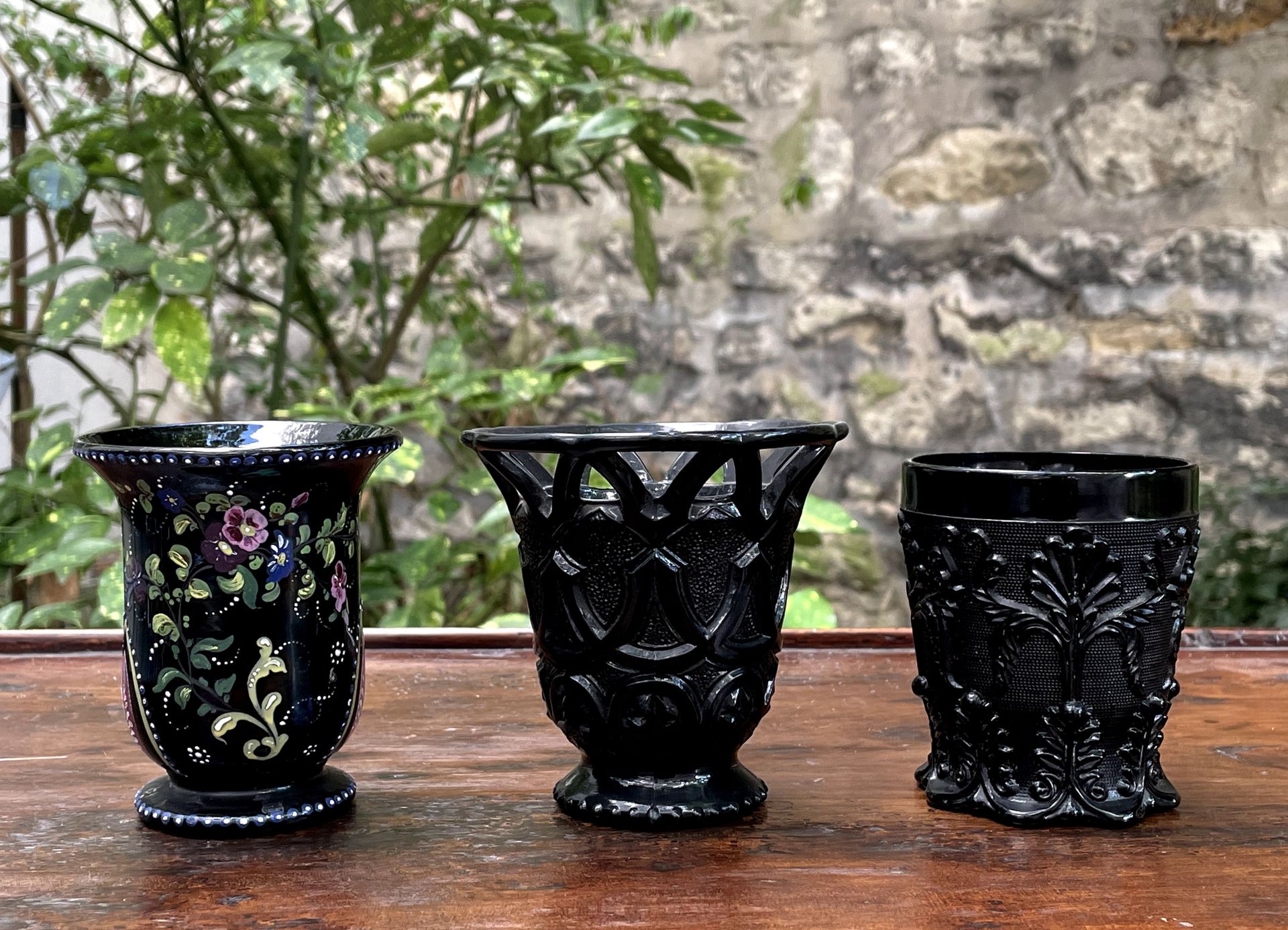 Null 一套三个黑色压制玻璃杯。 

一个是彩绘花，一个是刺桐叶，最后一个是镂空的几何图案。

19世纪

H.9,3 cm

H.9.4厘米

H.8.4厘&hellip;