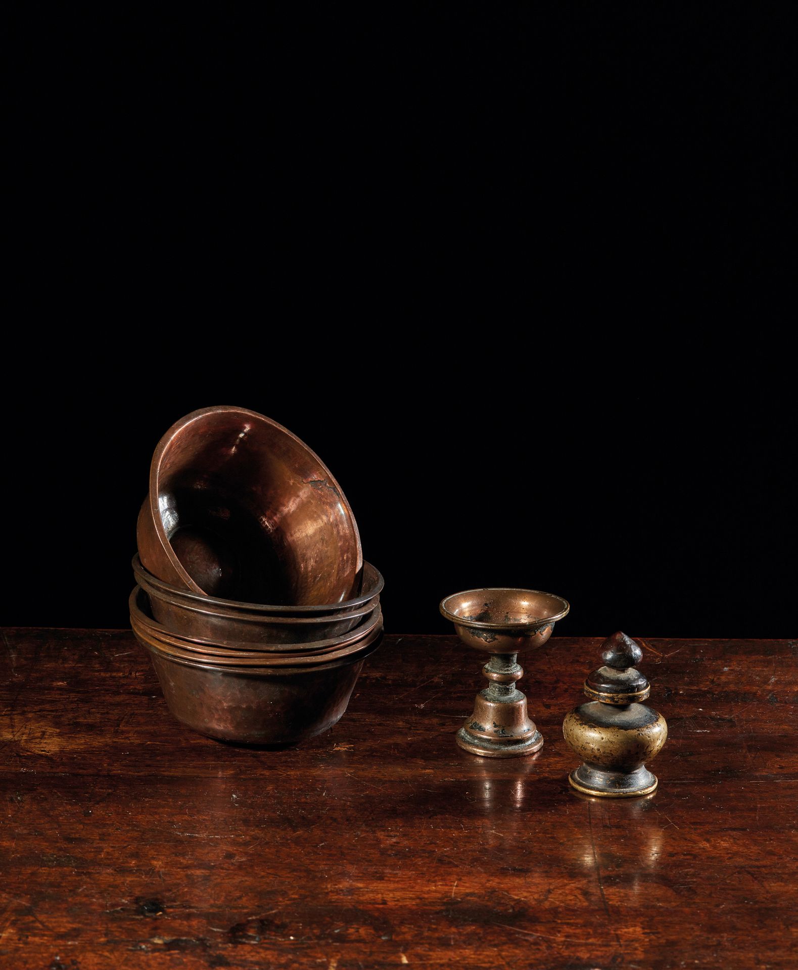 TIBET - XIXe siècle 套装包括七个铜碗，一个铜黄油灯和一个黄铜香水瓶（灯的边缘有修复）
碗直径10.2厘米，灯高6厘米，瓶高6厘米。