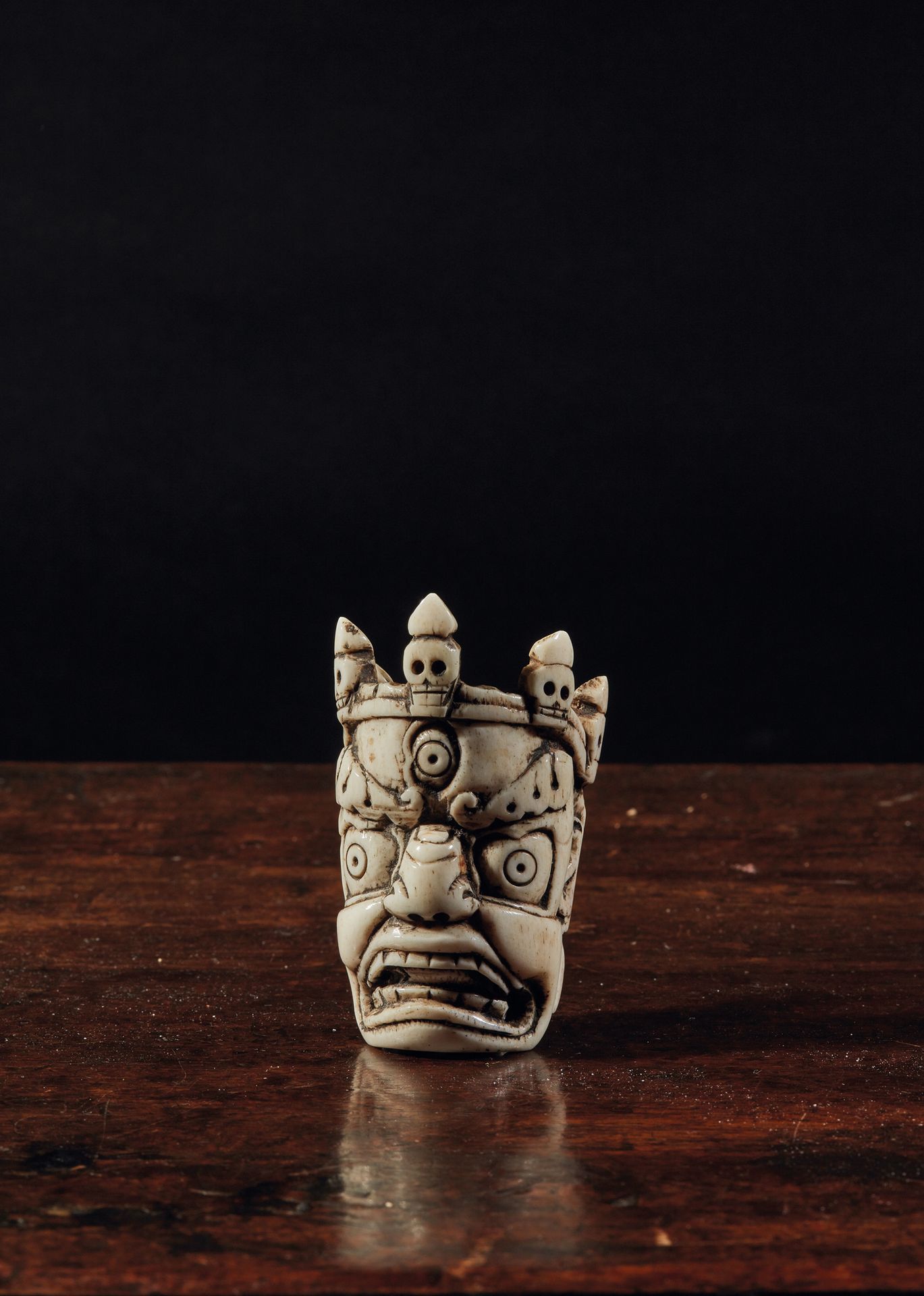 TIBET - XIXe siècle Mahakala head in carved bone, wearing a crown of skulls.
H. &hellip;