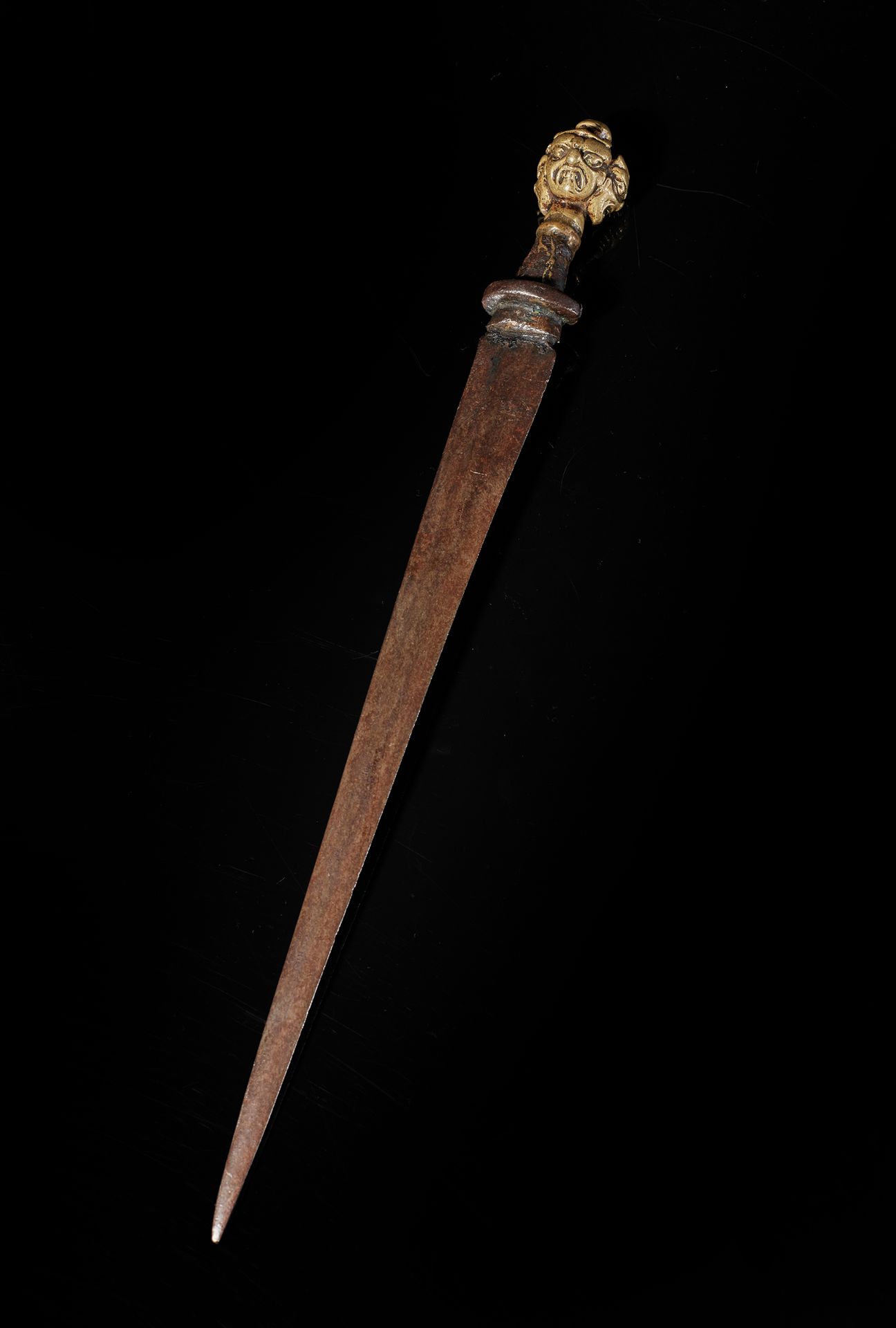 TIBET - XVIIe/XVIIIe siècle 匕首，黄铜手柄是三个马哈卡拉头的形状。
L. 29 cm