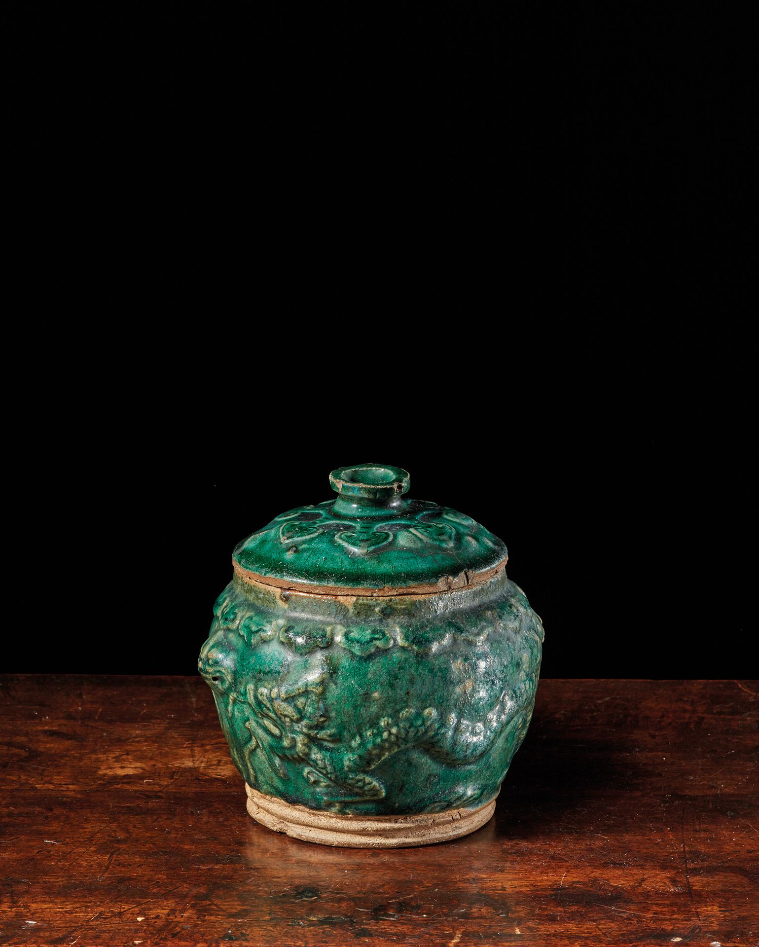 CHINE - XIXe siècle 绿松石釉炻器盖罐，釉下模印龙凤纹，边缘饰以灵芝楣。两个狮子头形状的把手。(小事故)。
高17厘米
