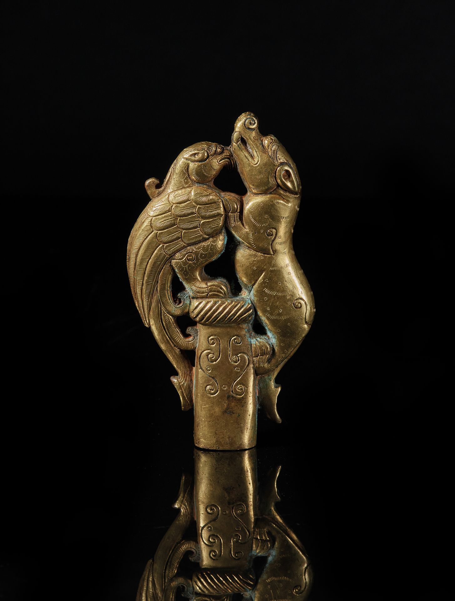 TIBET - XVIIe siècle 鎏金青铜装饰品，顶饰代表一只马卡拉和一只梦幻般的鸟儿面对面，毛发和羽毛被精细地凿开。
高12,5厘米