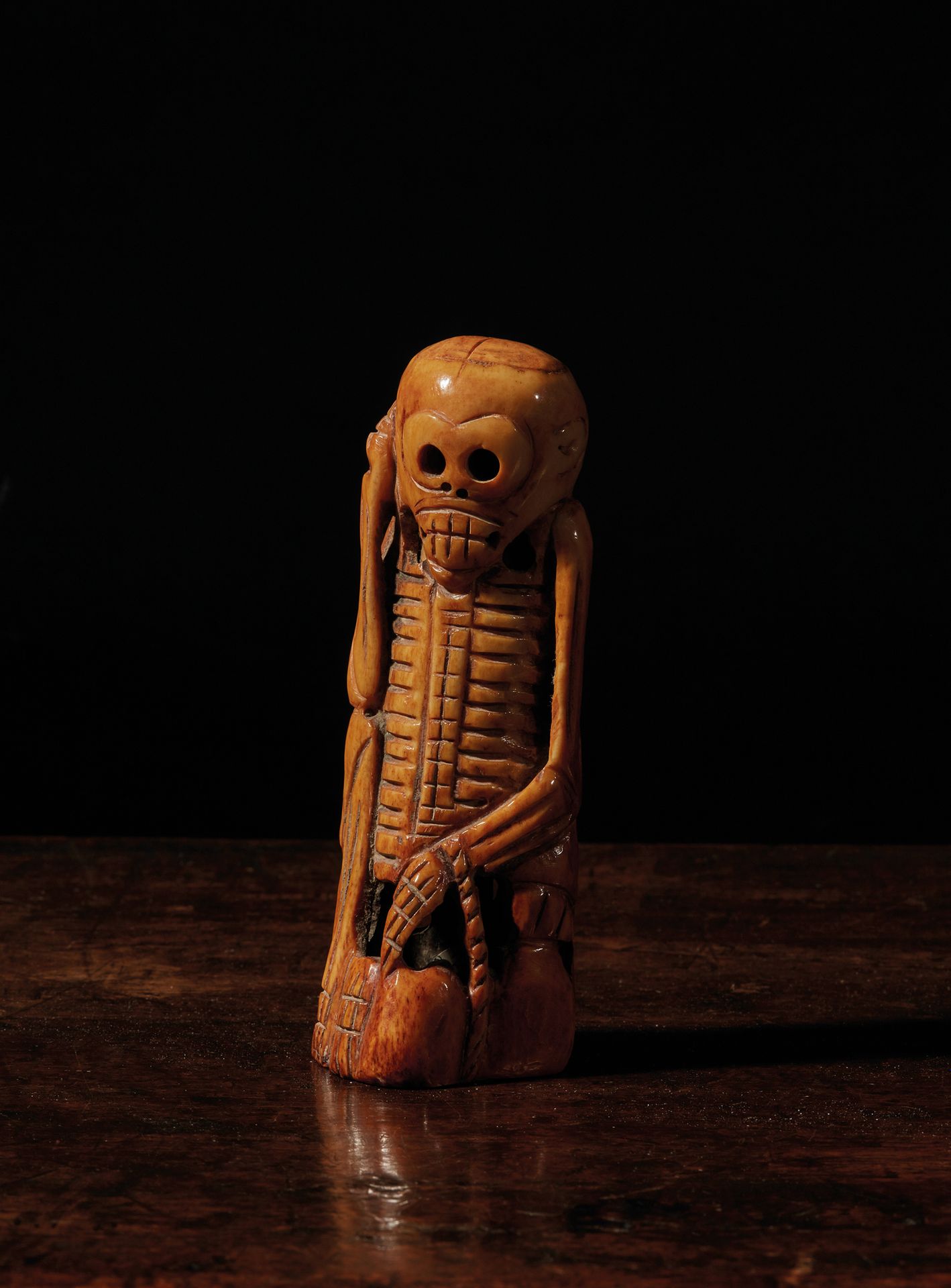 TIBET - XVIIe/XVIIIe siècle 密勒日巴骨雕像，棕色铜质骨雕，坐姿，右手放在右耳附近。
H. 13 cm