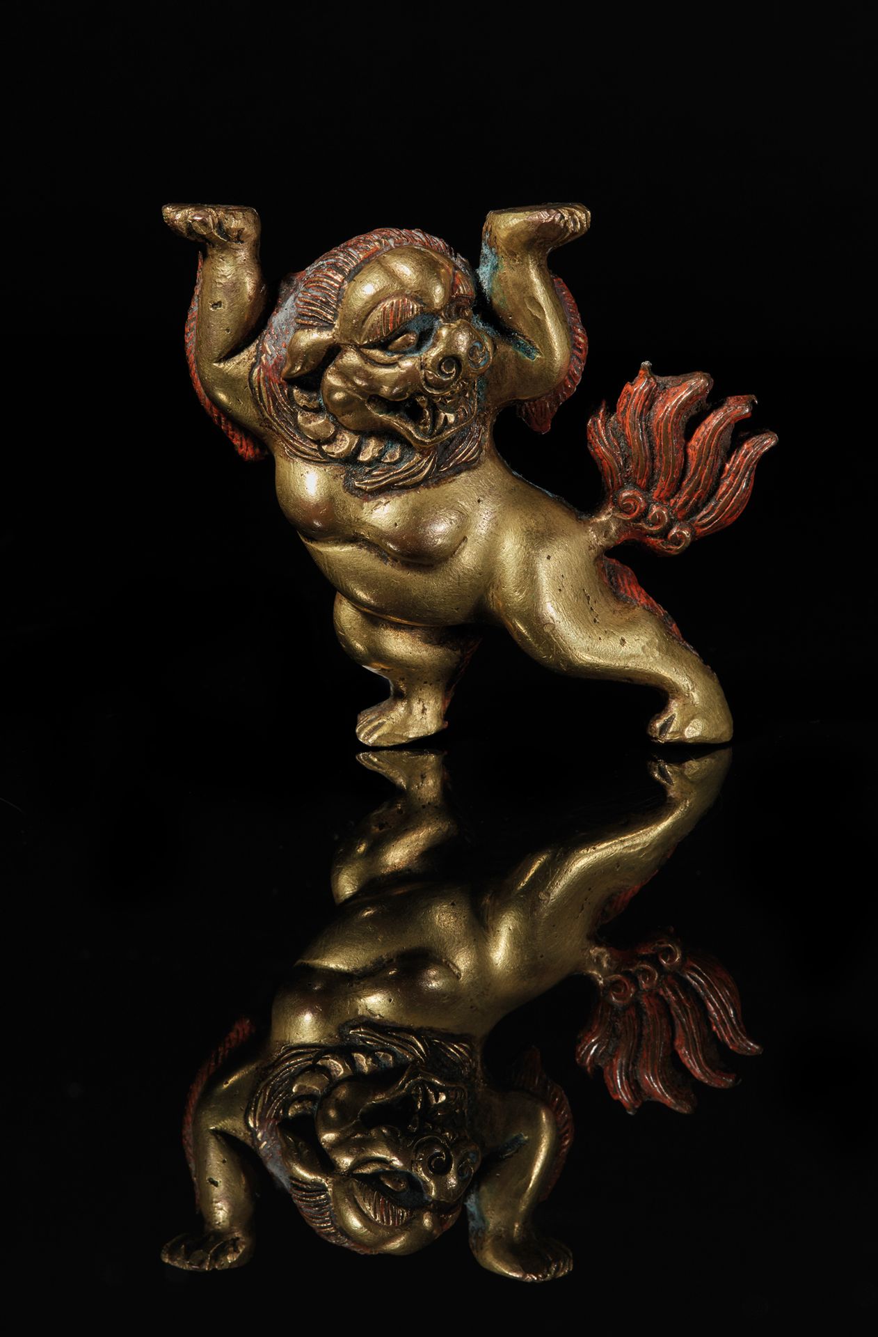TIBET - XVIIIe/XIXe siècle 一块镀金的雪狮铜牌，有多色的痕迹，爪子翘起。
高7厘米。
附有一个小的镀金压花铜牌，是一只站立的雪狮（修复&hellip;