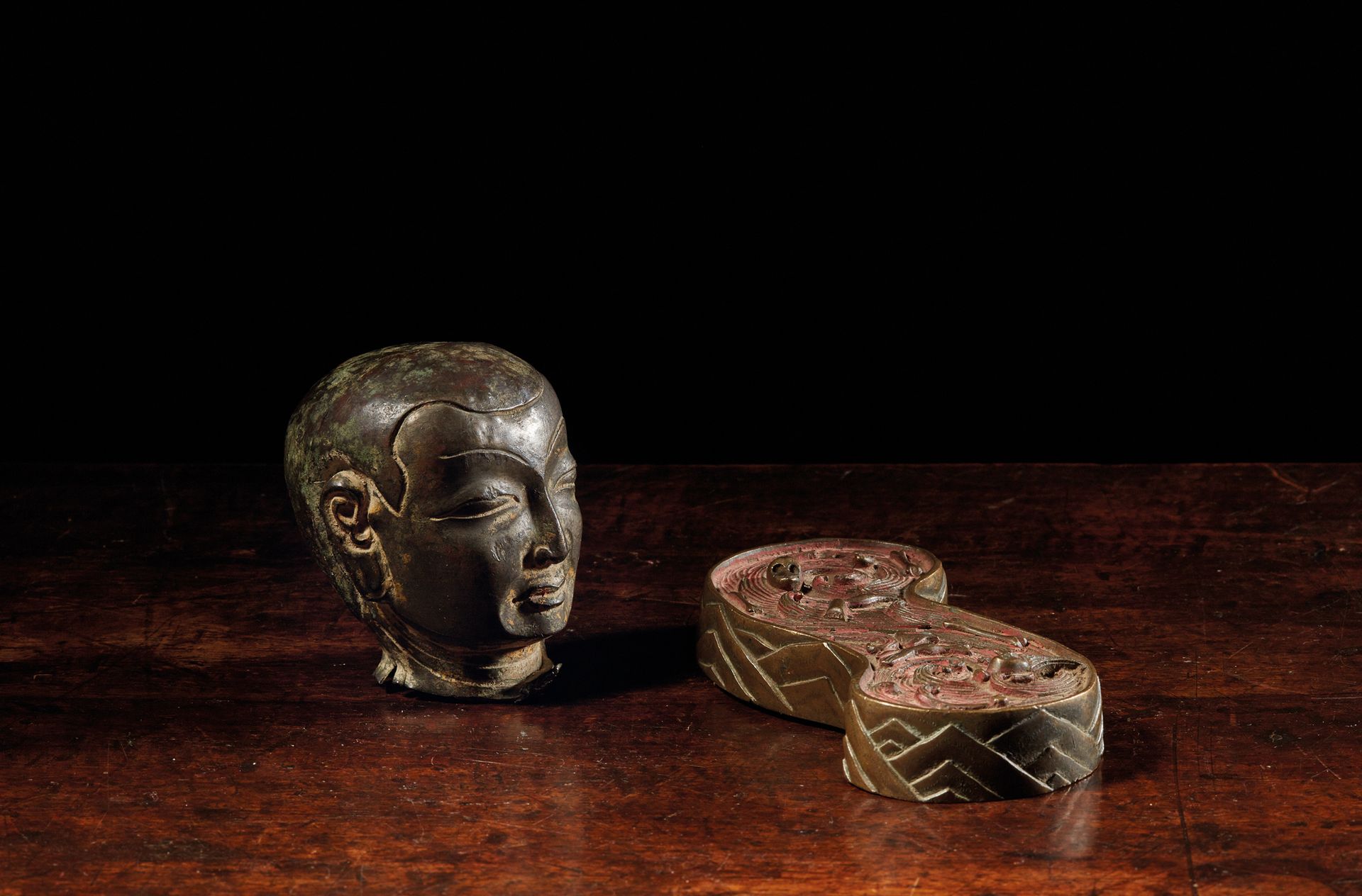 TIBET - XVIIe/XVIIIe siècle 套装包括一个青铜喇嘛头像，眼睛和眉毛都被精雕细琢（有多色的痕迹），以及一个有红色多色痕迹的黄铜底座，代表&hellip;