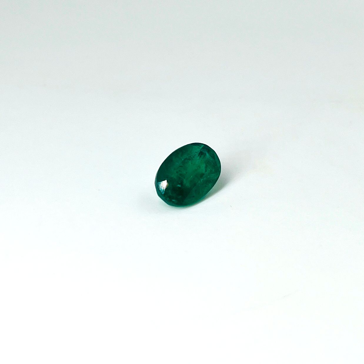 Null 椭圆形绿宝石，重4.73克拉。(附有AIG证书，显示 "鲜艳的绿色"，有轻微的油污处理："CEE (O) minor oil"。