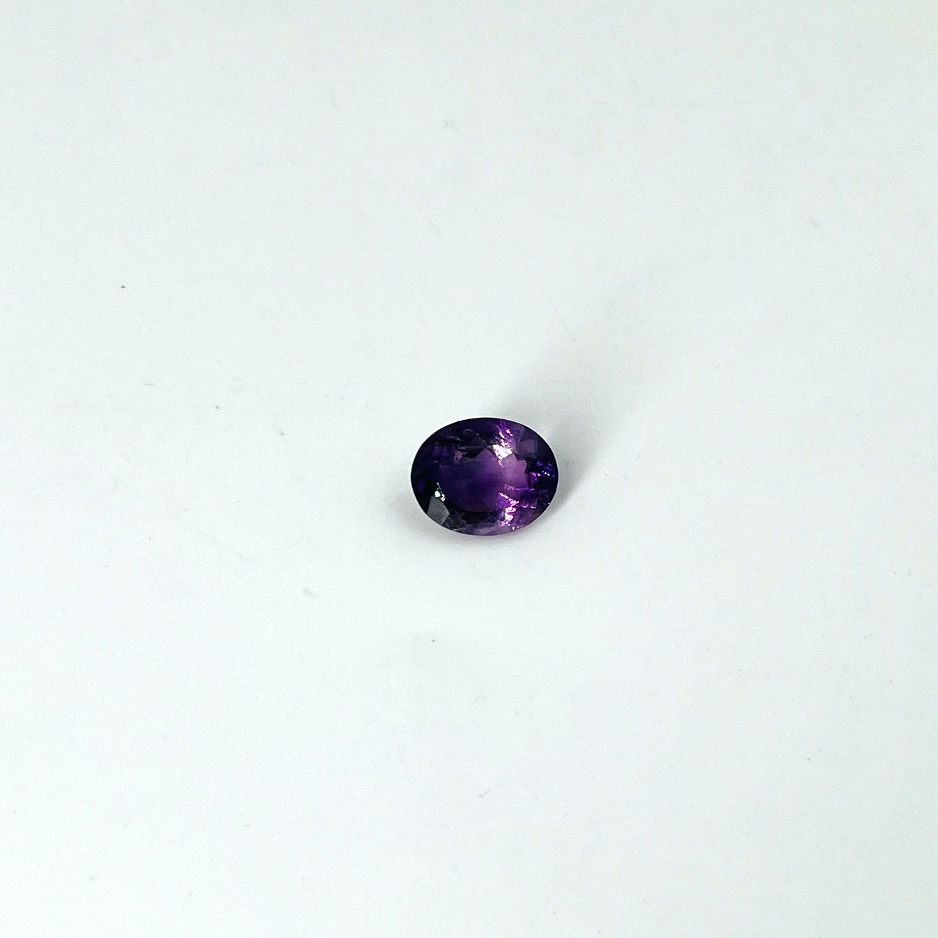 Null 椭圆形切面的紫水晶，重3.96克拉，可能来自巴西。尺寸：1.2乘以1厘米（小幅缺料）。