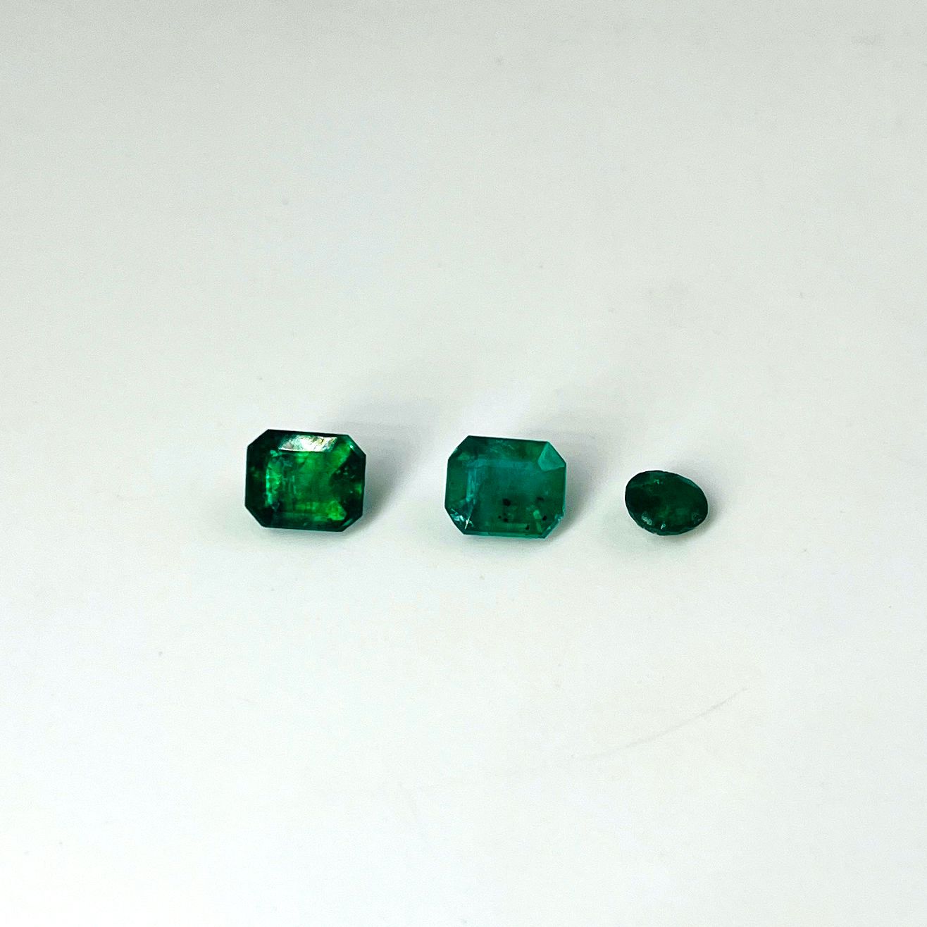 Null Lotto di tre smeraldi, due di taglio rettangolare, l'altro rotondo, per un &hellip;
