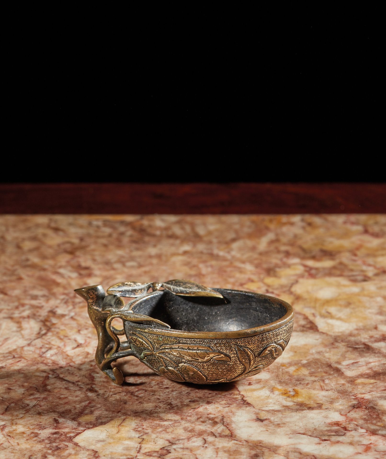 CHINE - Epoque KANGXI (1662 - 1722) 一个有水银镀金痕迹的青铜碗，形状为卷曲的植物，茎部形成一个把手。
长. 9,5厘米。