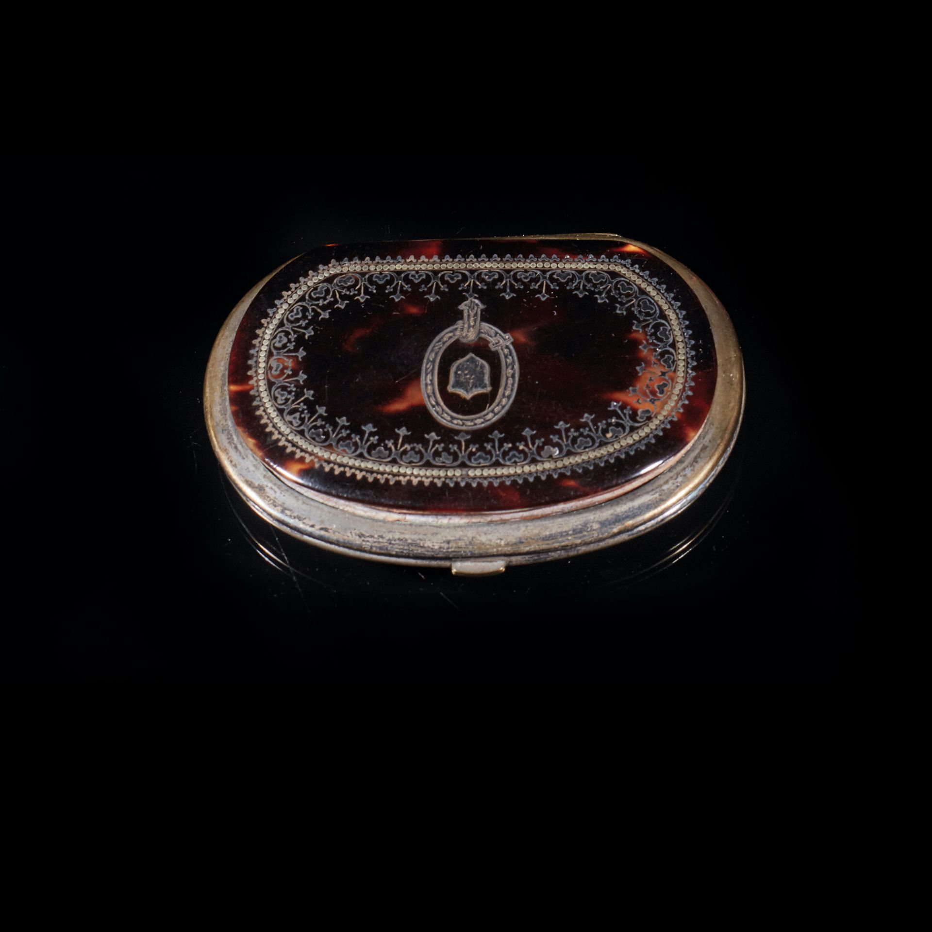 Null 一个镶银环、有凹痕的玳瑁肾形钱包，饰有百叶窗和盾牌。
长 8 厘米。
拿破仑三世时期。