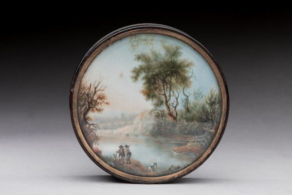 Null 圆形玳瑁盒，盒盖上装饰有描绘湖边风景的微型画。
19世纪中叶
直径：8厘米
(外壳有磨损和事故，盒子的底部可能原来有第二个微型的装饰，但没有了)