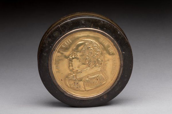 Null 圆角盒的盖子上装饰着一块印花板，代表法国国王路易十八的轮廓，是在德福杰的追逐下完成的。
总直径：8厘米
(对角的意外和对盖子的奖章的意外)