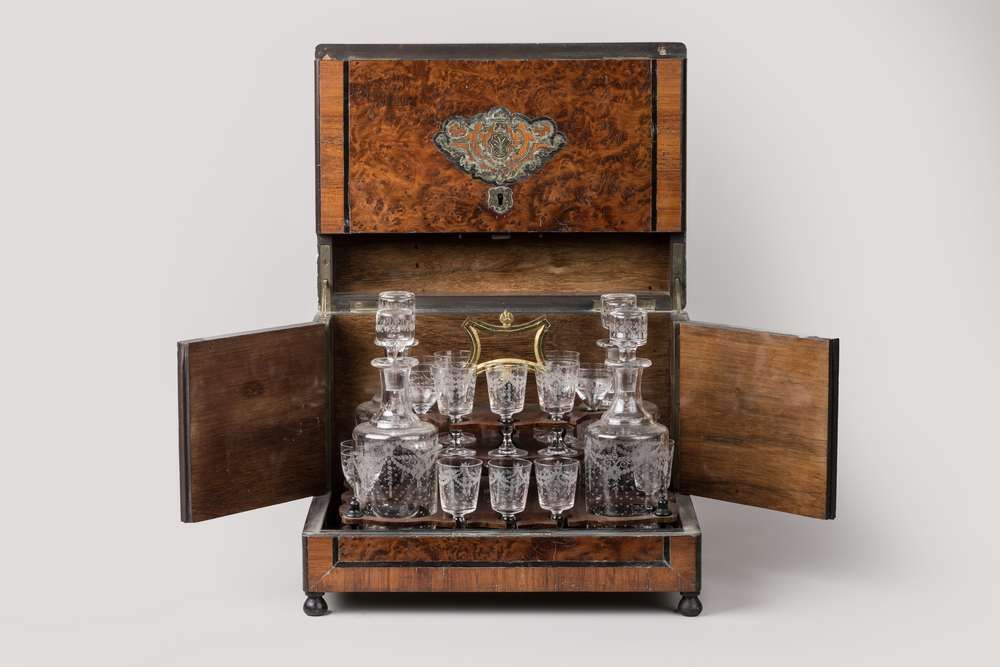 Null 一个毛刺贴面和黄铜镶嵌的酒柜，在熏黑的木框中。它站在四个小球脚上 
19世纪下半叶
高27厘米
(一个玻璃杯丢失，小的改动)