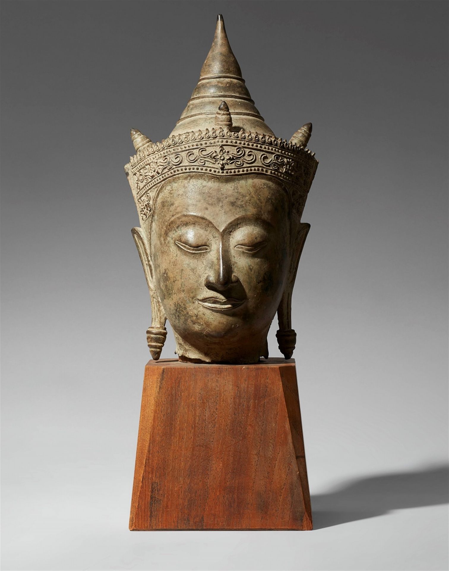 Null 大头的王公贵族装饰佛像。泰国，大城府，16/17世纪。



面部特征均匀，拱形眉毛下的眼睛呈弧形，嘴巴呈双重轮廓。头上有一顶装饰丰富的王冠，头顶和后&hellip;