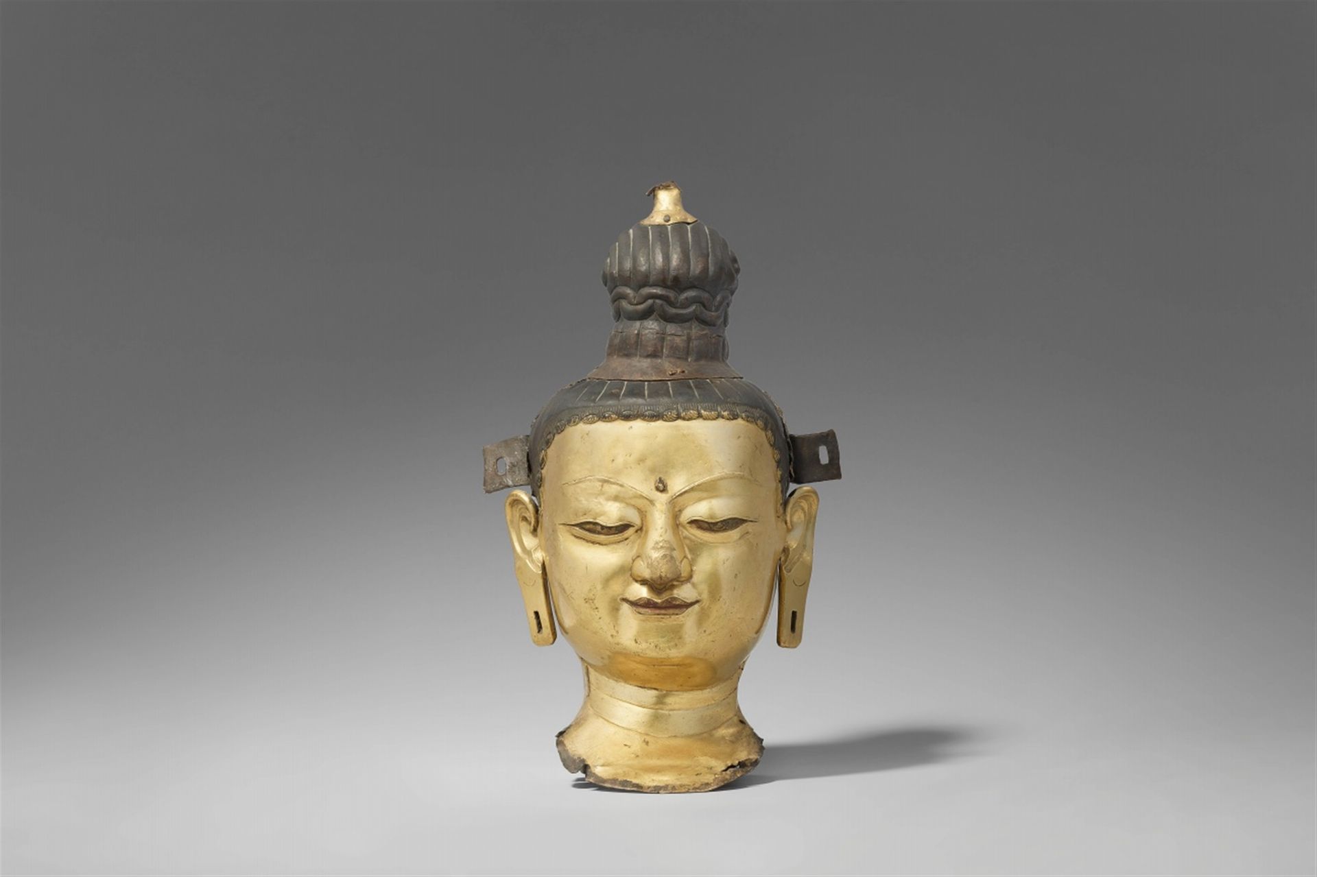 Null 菩萨的头像。铜质重塑，鎏金。西藏。18/19世纪。



脸部造型精细，嘴唇上带着安静的微笑，眼睛拉得很长，目光向内，头发堆成一个高高的发髻。嘴和眼睛&hellip;