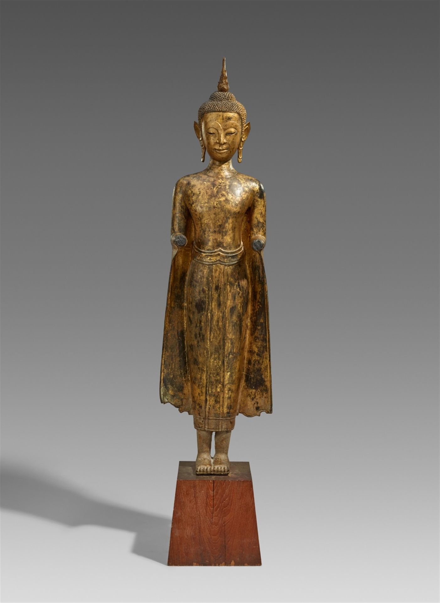 Null A large Ayutthaya lacquered and gilt bronze figure of a standing Buddha. Th&hellip;
