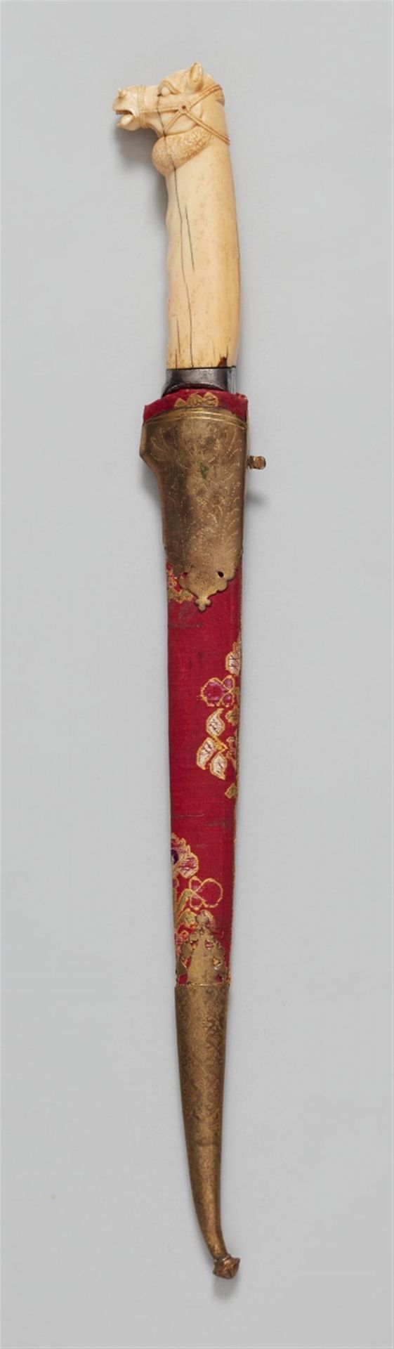 Null 匕首（卡片）。印度，莫卧儿王朝。 19世纪。



单刃钢刀，两边有中央凹陷，象牙握把有马头作为鞍座。木质刀鞘上覆盖着红磨丝织物，两端都镶嵌着冲压的铜&hellip;