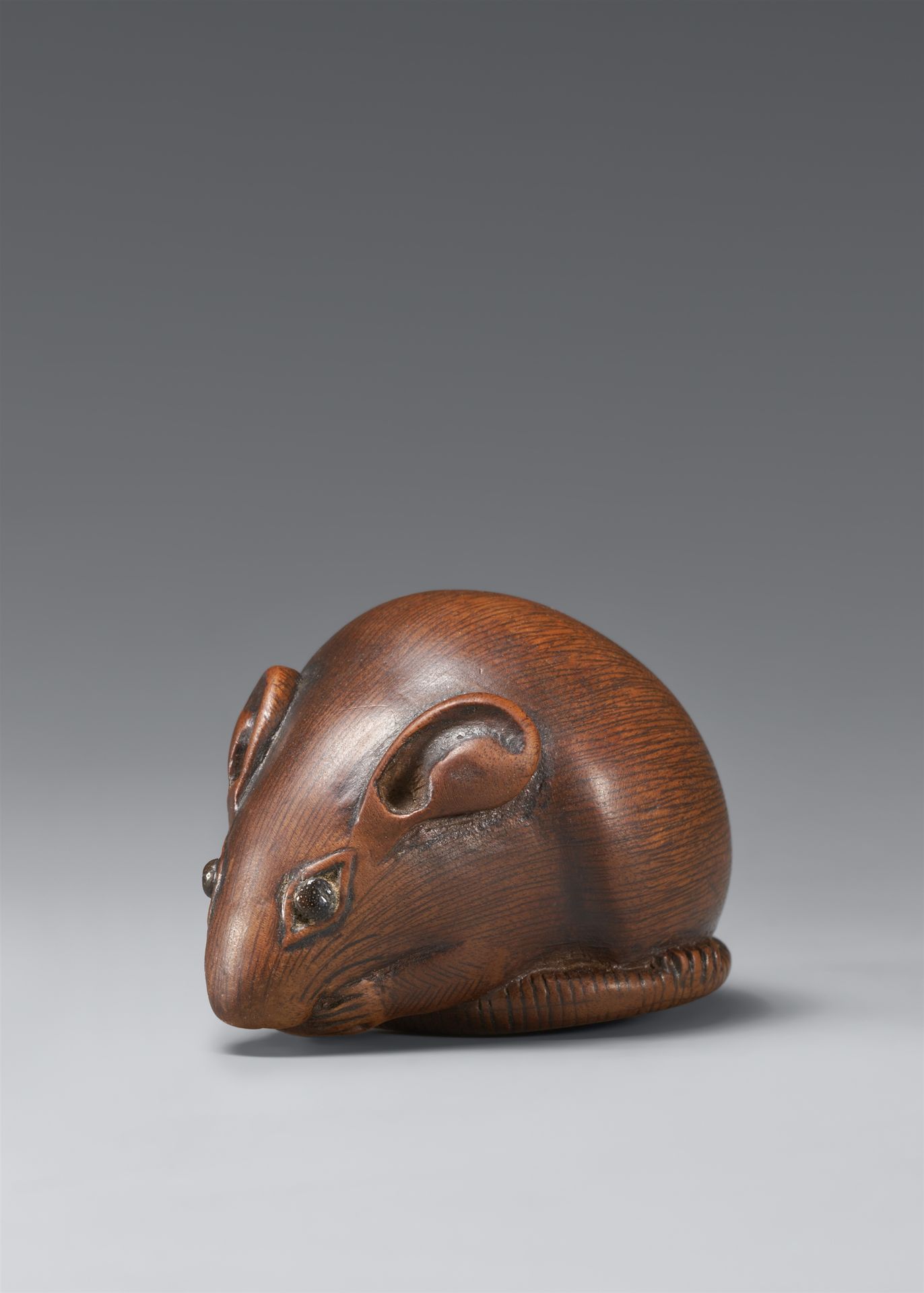 Null 坐着的老鼠。黄杨木。19世纪。



它用前爪把一个水果放在嘴边，后爪放在包裹着身体的尾巴上。黑木的眼睛。

高2,7厘米