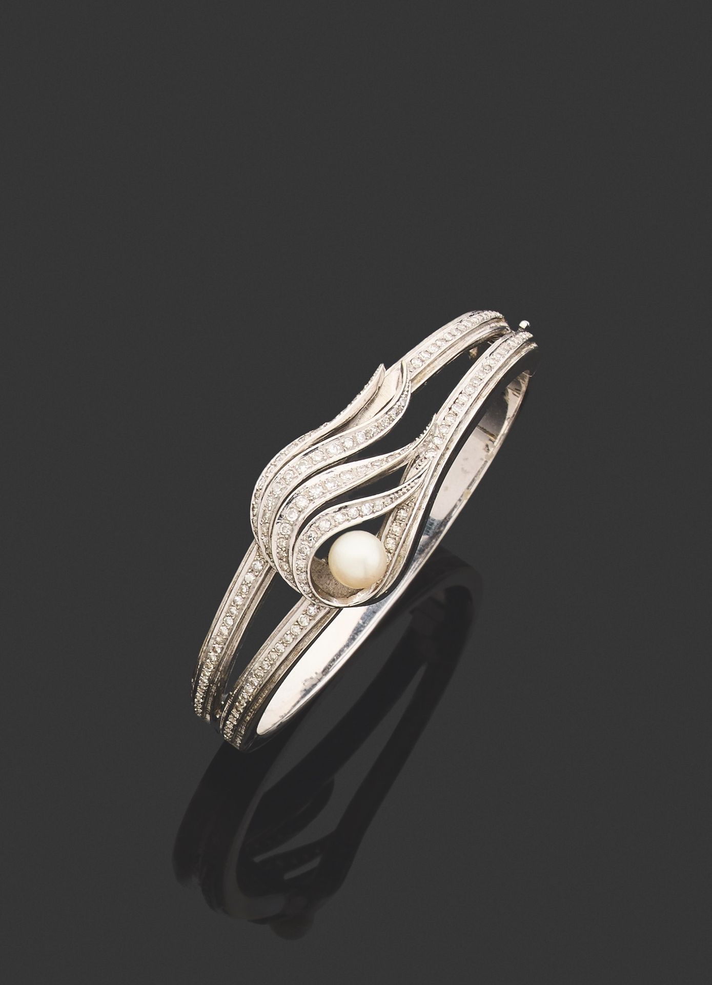 Null RIGID BRACELET. 
750 thousandths white gold, opening, centered on a leafy o&hellip;
