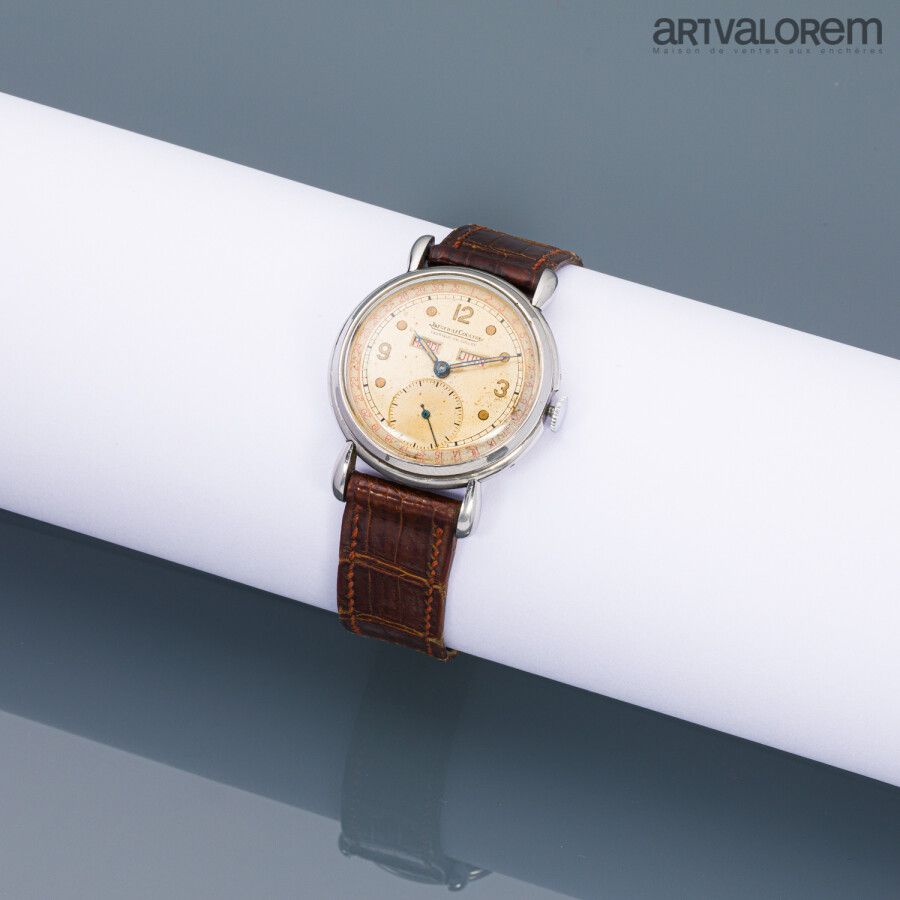 Null JAEGER-LECOULTRE 约1950年

镀铬金属腕表，有三层日历，米色表盘上有点状刻度和磷光阿拉伯数字，6点钟位置有秒针，花形指针。带手动上&hellip;