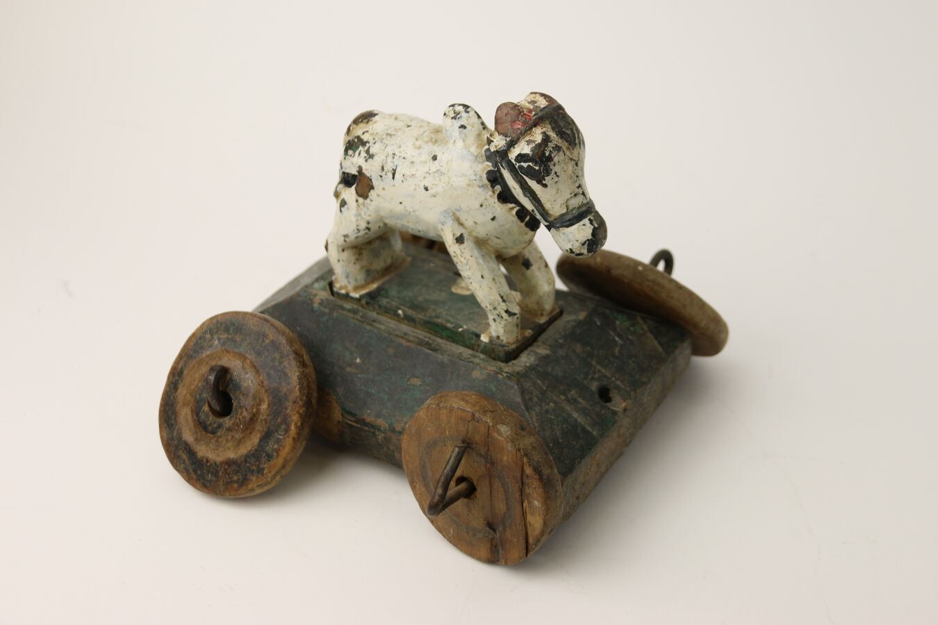 Null Small rustic toy with wheels representing a cow to pull.