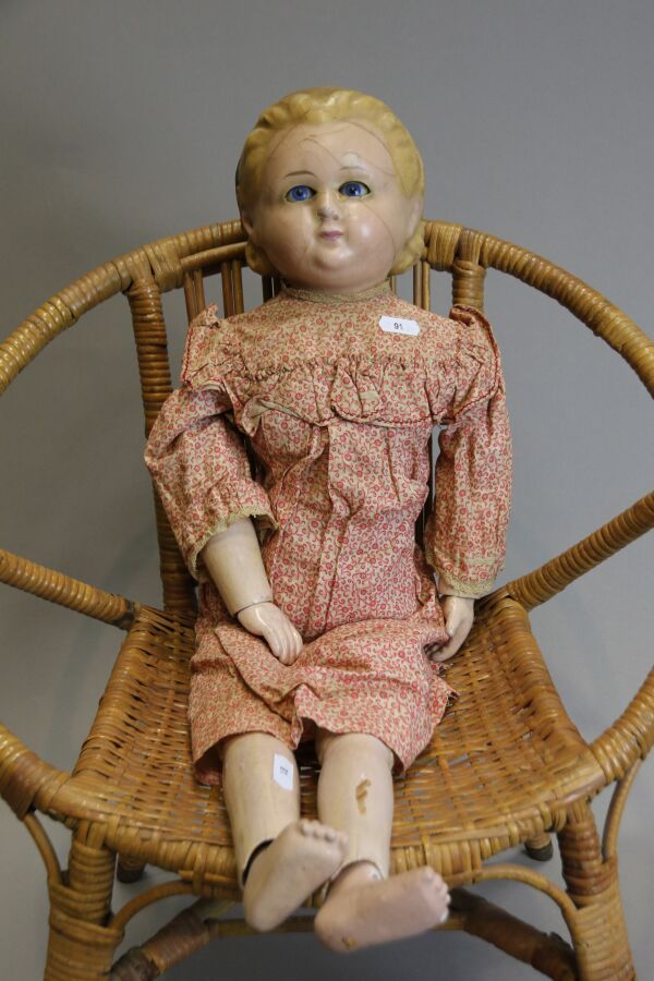 Null 19世纪的娃娃，蜡质的半身头，蓝色的睡眼，模压的头发，布质的身体，木质的胳膊和腿，铰接的手和脚，旧衣服，高：62厘米。