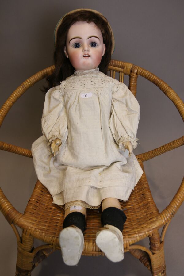 Null 法国娃娃，头部为平纹，嘴巴紧闭，标有 "LC DEPOSE P 11 G "的蓝色固定眼睛，身体笔直，有旧衣服和鞋子，高：61厘米。