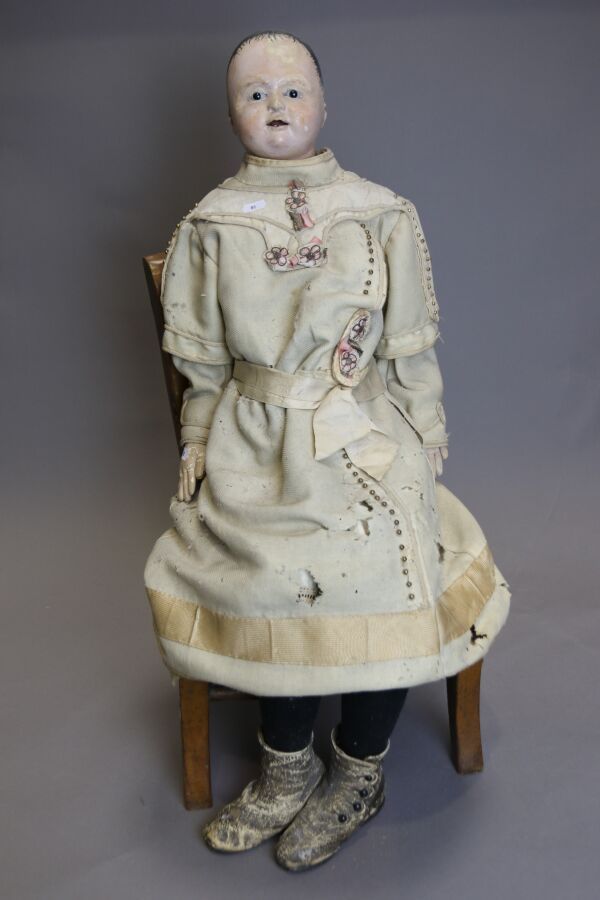 Null 德国娃娃，头部为纸塑，张嘴，黑色珐琅眼，身体为铰接式皮肤，旧衣服，高：87厘米，放在一张乡村椅子上。