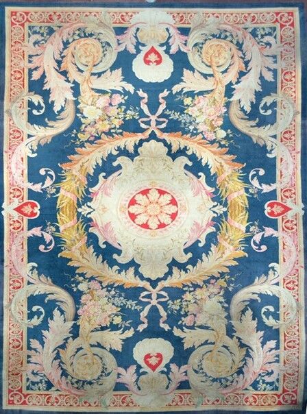 Null 19世纪末萨翁内里缝制的特殊和非常重要的地毯（英国）。

羊毛天鹅绒，棉质底板

普鲁士蓝的场地上装饰着一个非常大的中央象牙和红宝石徽章，其形式为贝壳&hellip;