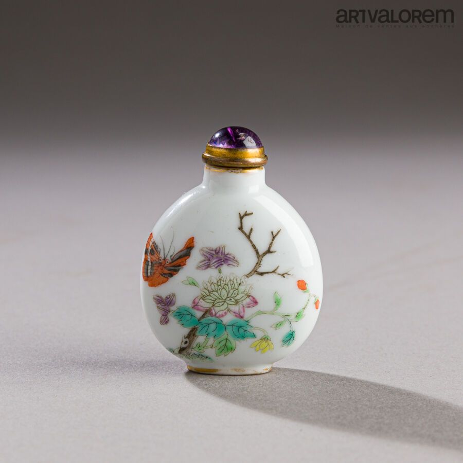 Null 中国，19世纪。背面有康熙的伪作标记。

鼻烟壶，上面有精致的蝴蝶装饰，在花和树枝之间。多色珐琅彩瓷器。紫水晶塞子，圈有铜。

高度：6厘米。